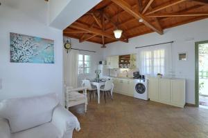Una sala de estar con una mesa y una cocina. en Skopelos villa Konstans, en Skopelos Town