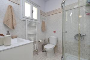 Un baño con inodoro y ducha de cristal. en Skopelos villa Konstans, en Skopelos Town 52 fotos más