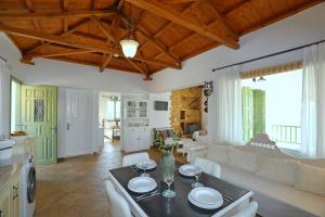 Una cocina y una sala de estar con mesa y sillas. en Skopelos villa Konstans, en Skopelos Town