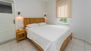 a bedroom with a large white bed and a window at Golden Lighthouse Hotel in Patara