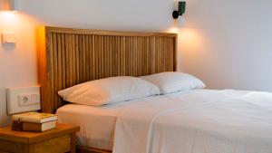 a bedroom with a bed with a wooden headboard at Golden Lighthouse Hotel in Patara