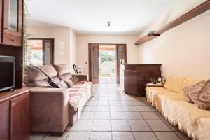 Una sala de estar con dos sofás y un televisor. en Suíte da Casa da Mi, en Porto Belo