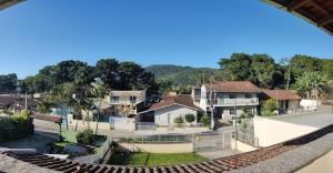 vistas a una pista de tenis con casas y árboles en Suíte da Casa da Mi, en Porto Belo