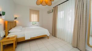 a bedroom with a bed and a large window at Golden Lighthouse Hotel in Patara
