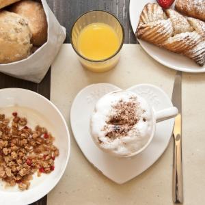 a table with plates of bread and a cup of coffee at Hotel Garnì Villa Maria in Riva del Garda