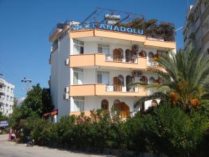 a tall white building with a sign on it at Hotel Anadolu in Finike