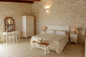 a bedroom with a bed and a table and a mirror at Masseria Surace in Noci