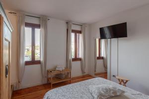 a bedroom with a bed and a flat screen tv at BACARìA DA DANTE Rooms in Bassano del Grappa