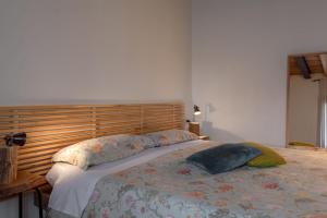 a bedroom with a large bed with a wooden headboard at BACARìA DA DANTE Rooms in Bassano del Grappa