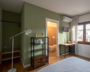 a bedroom with a green wall with a bed and a lamp at BACARìA DA DANTE Rooms in Bassano del Grappa +79 photos