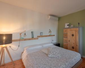 a bedroom with a bed and a lamp and a dresser at BACARìA DA DANTE Rooms in Bassano del Grappa