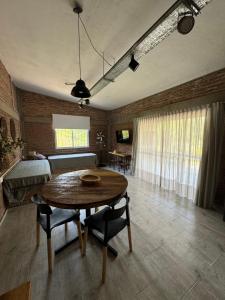 a living room with a table and a bedroom at Cabañas Cuesta in Cordoba