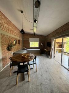 a dining room with a table and a brick wall at Cabañas Cuesta in Cordoba