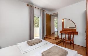 - une chambre avec 2 lits, un miroir et un bureau dans l'établissement Nice Apartment In Mundanije With Wifi, à Mundanije