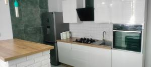 a kitchen with white cabinets and a stainless steel refrigerator at Apartament Starachowice in Starachowice