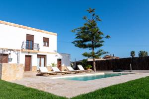 una villa con piscina di fronte a una casa di Lo Mas de Paiall a Deltebre