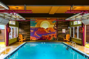 a swimming pool in a house with a mural at Hotel Zed Victoria in Victoria