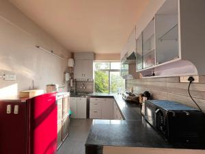 cocina grande con nevera roja. en Primrose Apartment, en Darjeeling