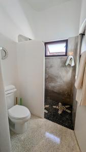 Un pequeño baño con inodoro y ventana. en Los Gallos - Suite, en Lo de Marcos