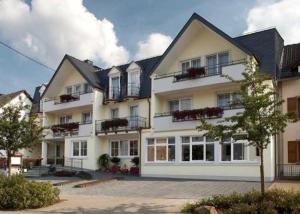 a large white building with windows and balconies at Hotel Die Post Meerfeld in Meerfeld