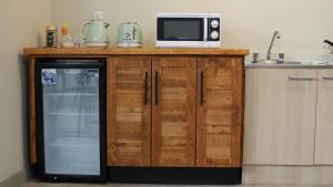 a kitchen with a microwave and a refrigerator at Alternativo Hostales in Caldera