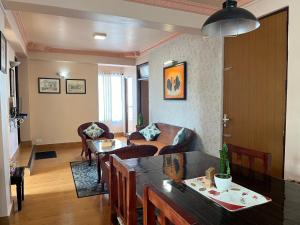 una sala de estar con un sofá y una mesa en Primrose Apartment, en Darjeeling