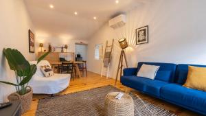 a living room with a blue couch and a table at Pátio Vilareto - Villa Fernanda in São Domingos de Rana
