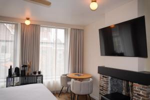 a hotel room with a bed and a table and a tv at Boutique Hotel Johannes in Delft