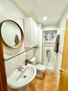 a bathroom with a sink and a toilet and a mirror at Vivienda céntrica cerca de todo in Alicante