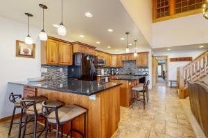 a kitchen with wooden cabinets and a large island with bar stools at Lion Square Lodge East 310 in Vail