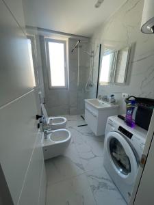 a bathroom with a washing machine and a toilet at Vollgaapartment2 in Durrës +14 photos