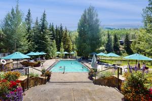 a swimming pool with blue umbrellas and flowers at Lion Square Lodge East 310 in Vail