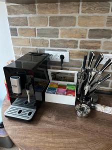 a coffee maker on a table next to a brick wall at Casa Ana in Câmpulung Moldovenesc