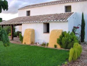 Fuentes de CesnaCortijo el Morrón - Casa Rural的白色房子,有两个大干草包