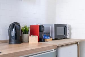 a kitchen counter with a coffee maker and a microwave at LP Apartments - Navigli in Milan