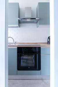 a kitchen with a black oven and a sink at LP Apartments - Navigli in Milan