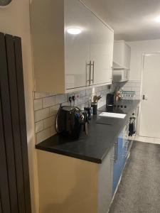 a kitchen with white cabinets and a black counter top at Harcourt Road in Nottingham