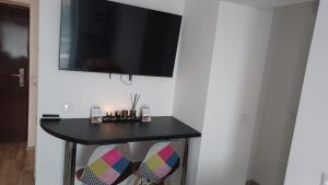a black table with a flat screen tv on a wall at Steffi Apartment in Balş