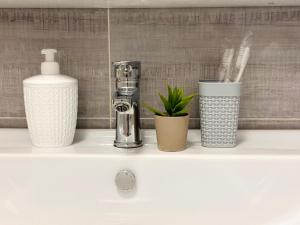 ein Regal mit einem Seifenspender und anderen Gegenständen darauf in der Unterkunft Солнечная квартира на высоком этаже in Almaty