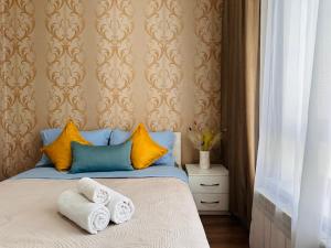 ein Schlafzimmer mit einem Bett mit Handtüchern darauf in der Unterkunft Солнечная квартира на высоком этаже in Almaty