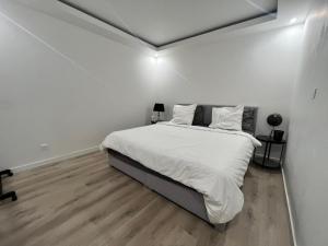 a white bedroom with a bed with white sheets and pillows at Magnifique maison en plein centre ville in Rouen