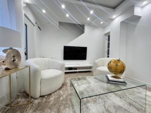 a living room with two chairs and a television at Magnifique maison en plein centre ville in Rouen