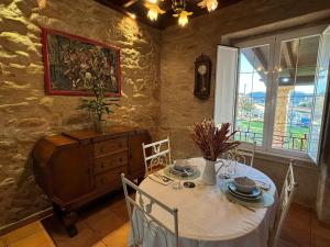 a dining room with a table with chairs and a clock at Casa de Romaxe in Muros