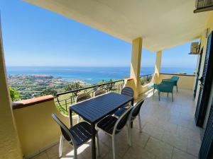 a balcony with a table and chairs and the ocean at Marasusa Apartments Maestrale 216C in Parghelia
