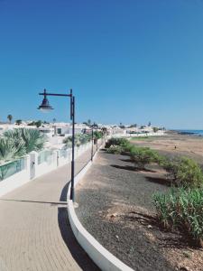 a sidewalk next to the beach with a street light at Villa Mirakai in Playa Honda