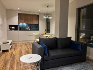 a living room with a black couch and a table at Three Little Birds in Guimarães