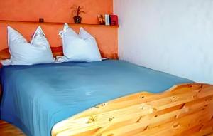 a bed with blue sheets and white pillows at Wohnung Templin Ot Dargersdorf in Dargersdorf