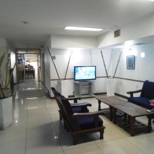 una sala de espera con sillas, mesa y TV en Adrazi Internacional en Buenos Aires