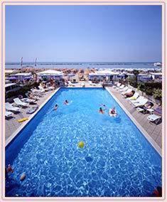 uma grande piscina com pessoas ao lado da praia em Hotel Italia em Bellaria-Igea Marina