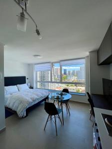 a bedroom with a bed and a table with chairs at Departamento studio nuevo en Concepcion in Concepción